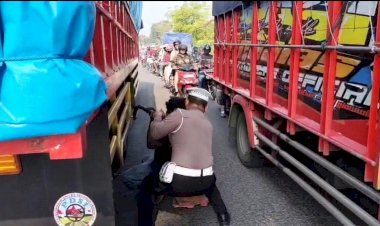 Salut,-Pak-Polisi-ini-Bantu-Sopir-Truk-Ganti-Ban-di-Tengah-Padatnya-Lalin-Gresik